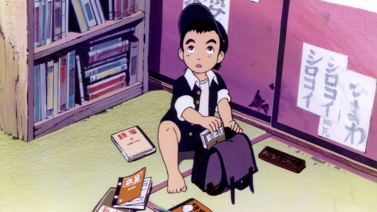 A young boy in a traditional Japanese home looks up while putting a book in his backpack.